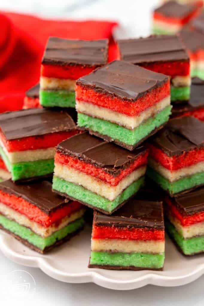 a plate of tri colored Italian rainbow cookies, stacked neatly
