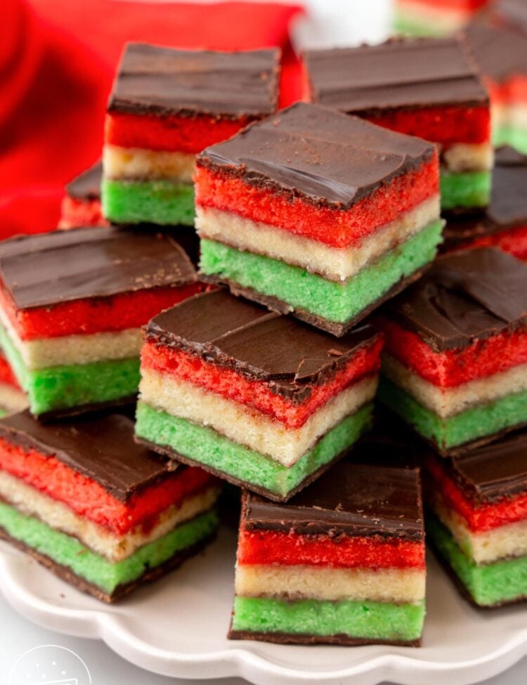 a plate of tri colored Italian rainbow cookies, stacked neatly