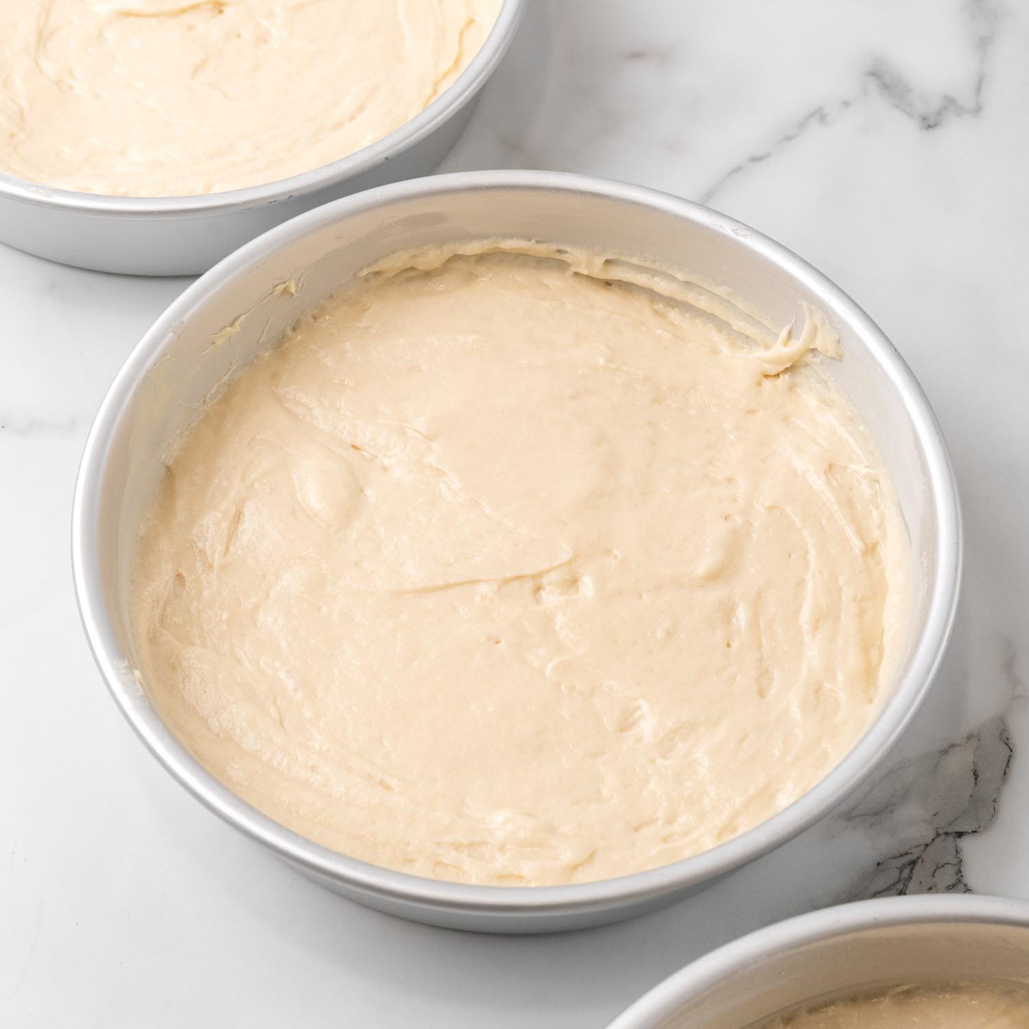 lane cake batter in three round pans.