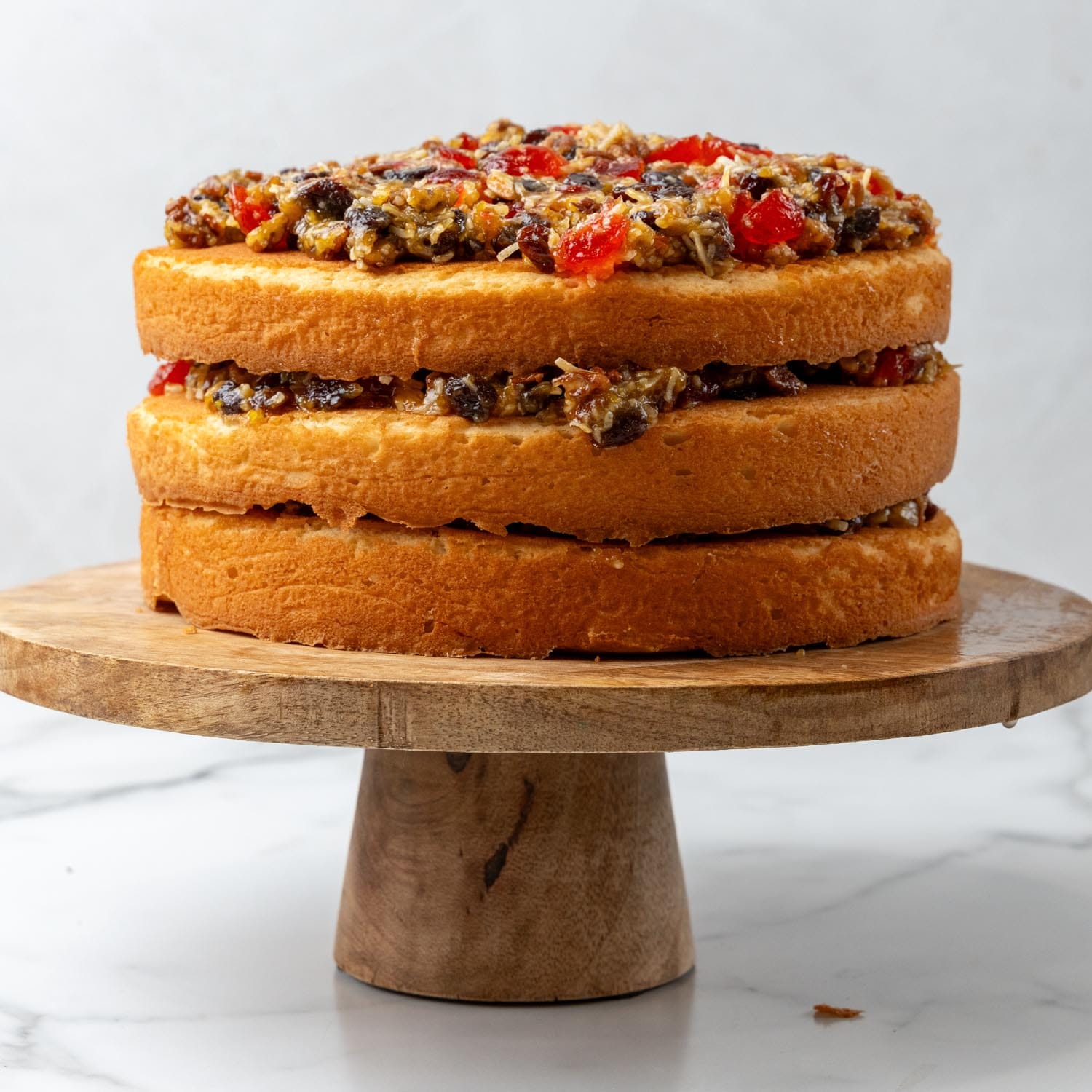 lane cake in three layers on a wooden pedestal, before frosting.