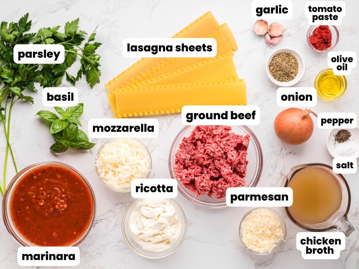 The ingredients for lasagna soup with ground beef, marinara, and ricotta, measured and arranged on a marble counter.