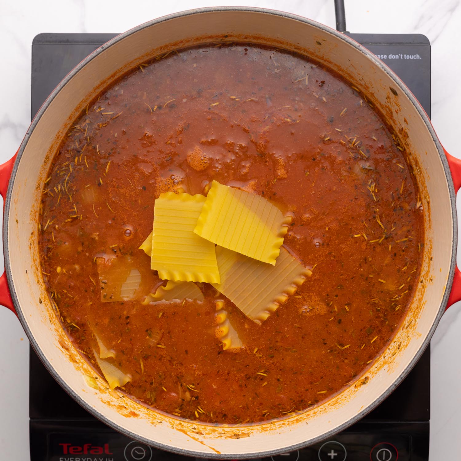 lasagna noodles, broken into pieces, added to a pot of soup.