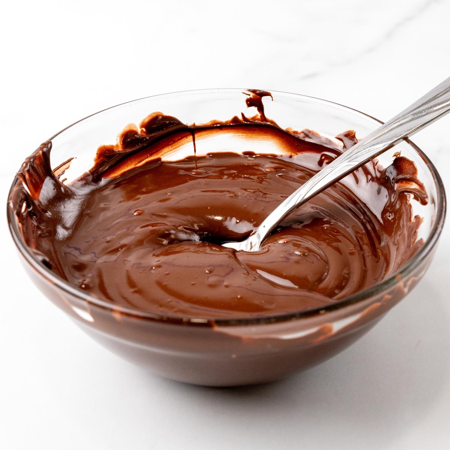 melted chocolate chips in a small glass bowl with a spoon.