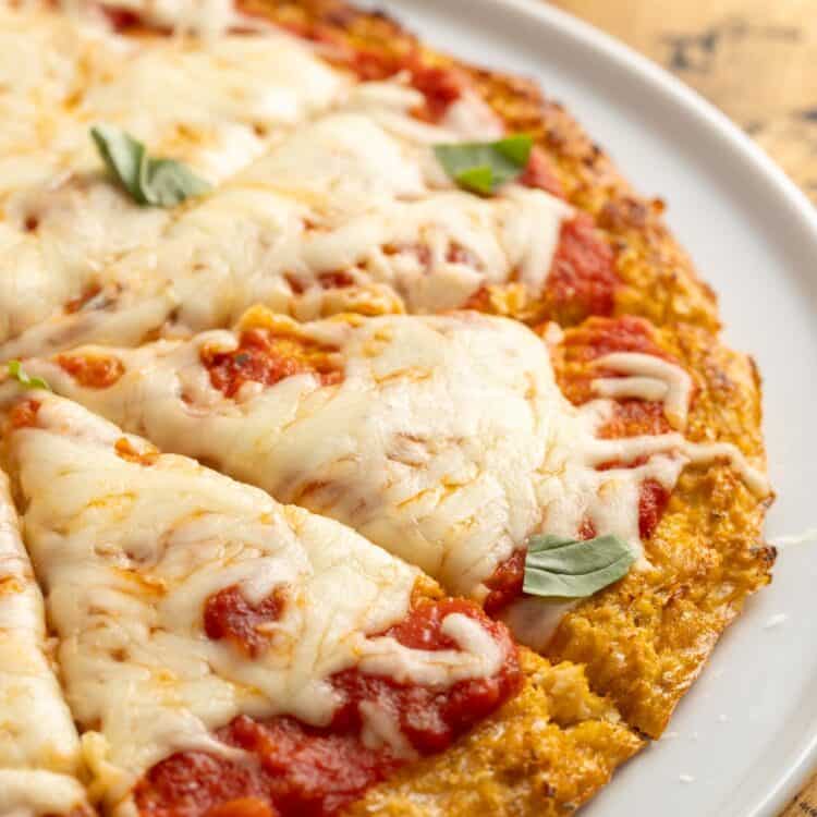 closeup view of a cauliflower pizza crust pizza on a plate.