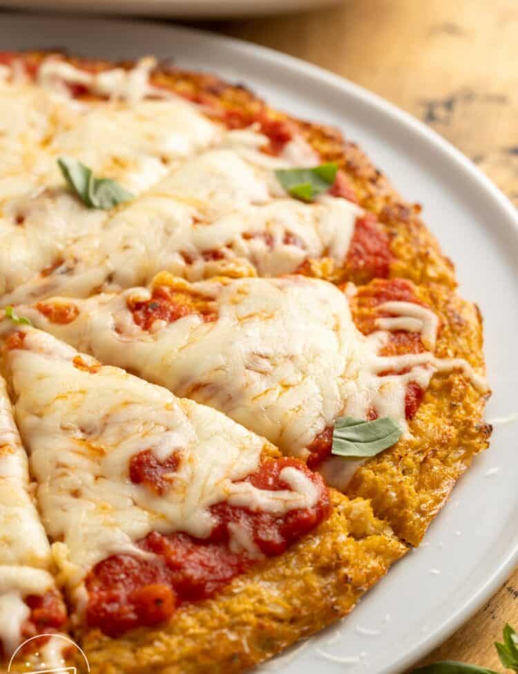 closeup view of a cauliflower pizza crust pizza on a plate.