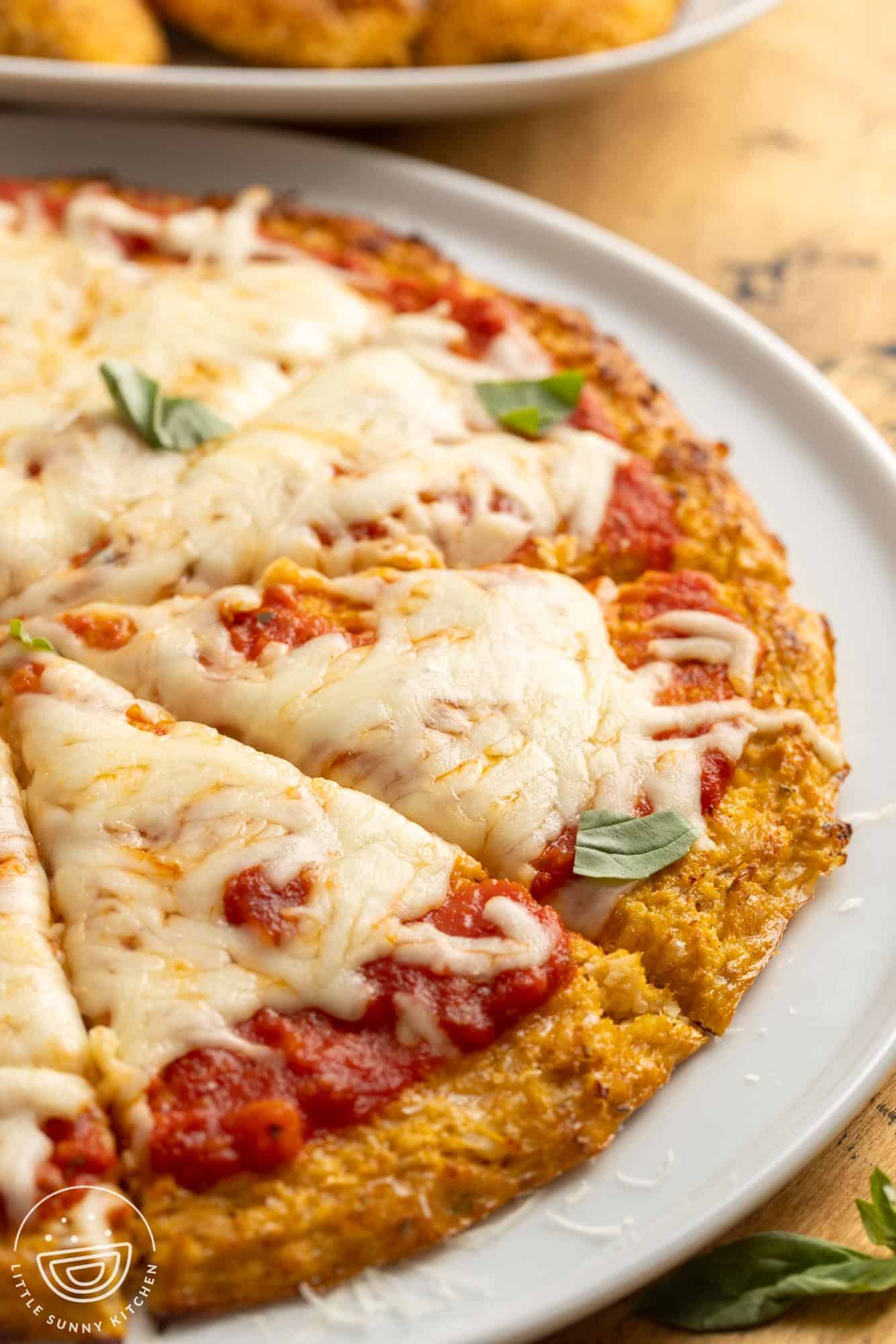 closeup view of a cauliflower pizza crust pizza on a plate.