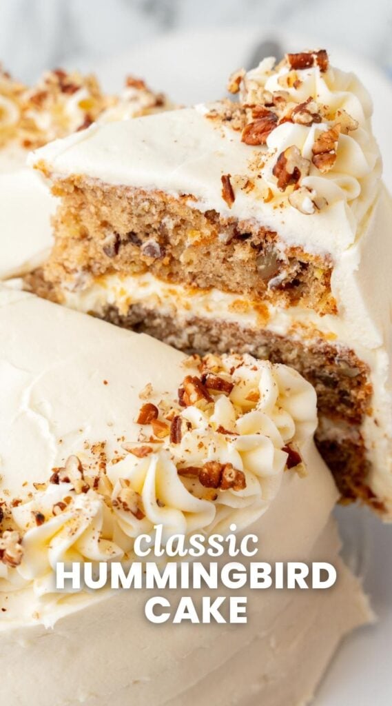 a slice of hummingbird cake lifted away from the whole cake. Text overlay says "classic hummingbird cake"