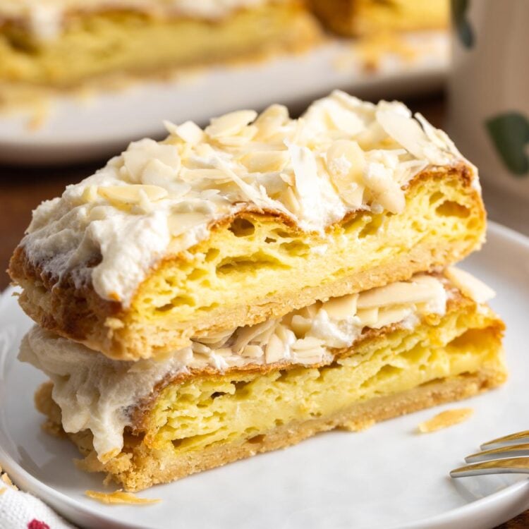 two slices of Danish puff pastry with almonds on a small white plate.