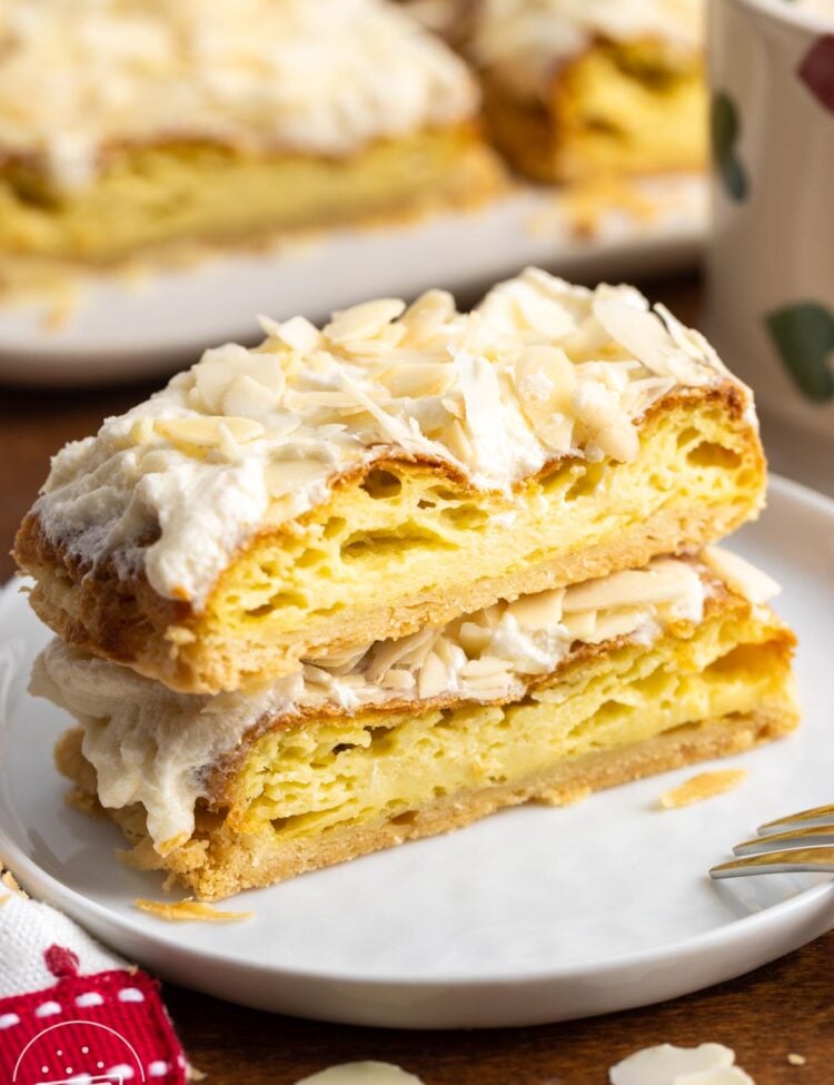 two slices of Danish puff pastry with almonds on a small white plate.