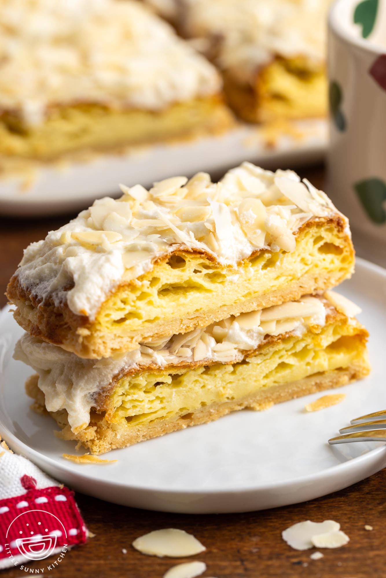 two slices of Danish puff pastry with almonds on a small white plate.