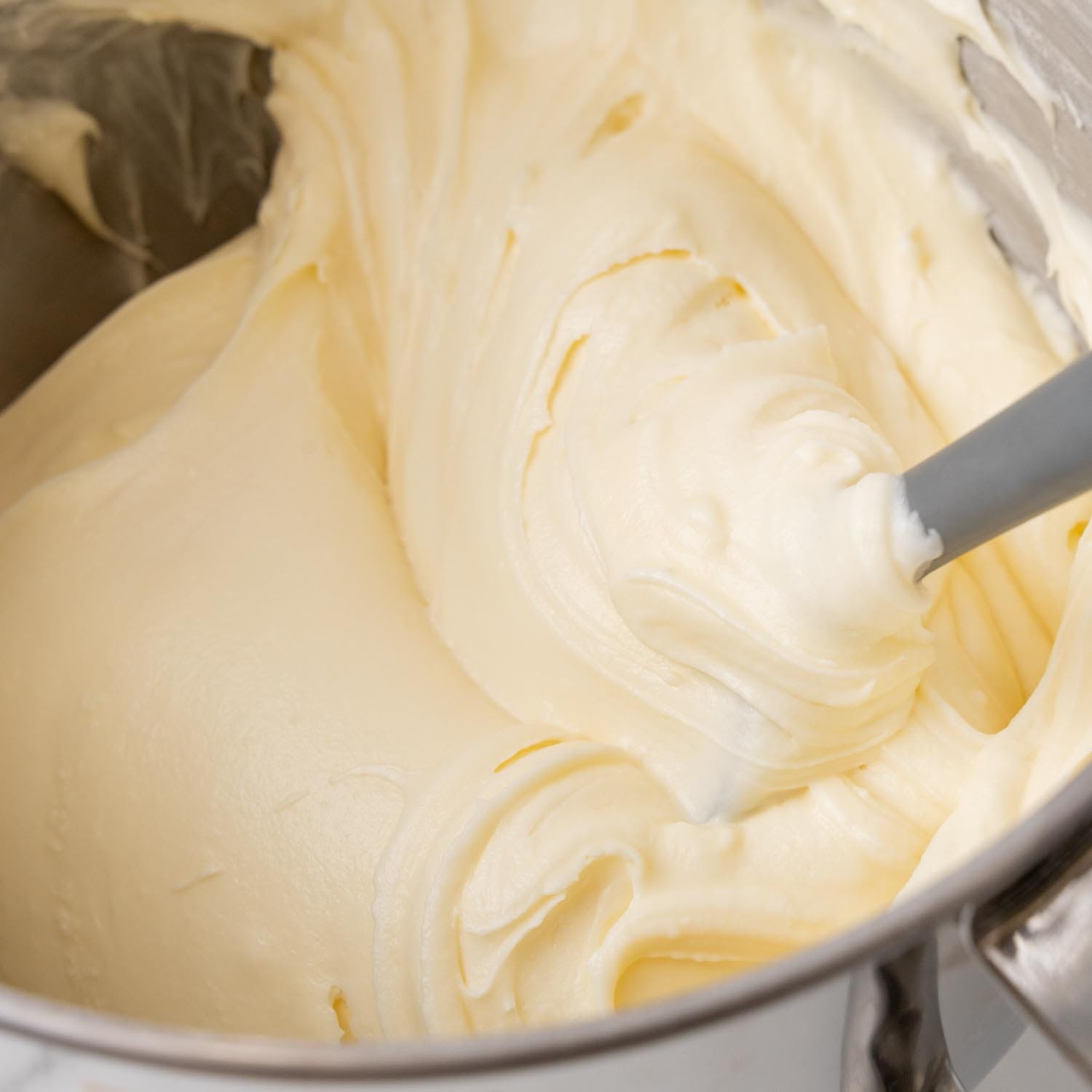 creamy cream cheese frosting in the bowl of a stand mixer.