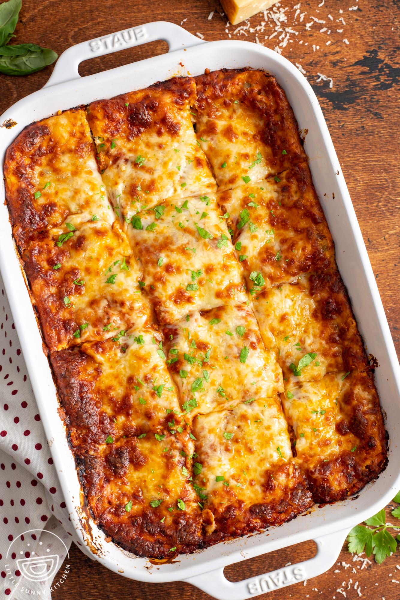 overhead view of a pan of lasagna cut into 12 squares.