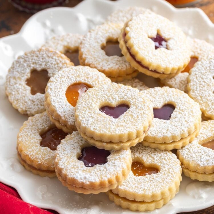 a platter of sandwich linzer cookies dusted with powdered sugar.