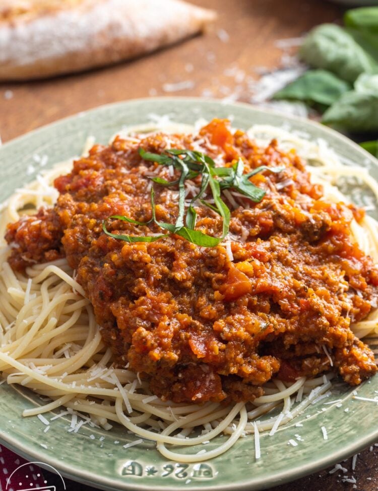 a light green plate of spaghetti and meat sauce with hidden vegetables.