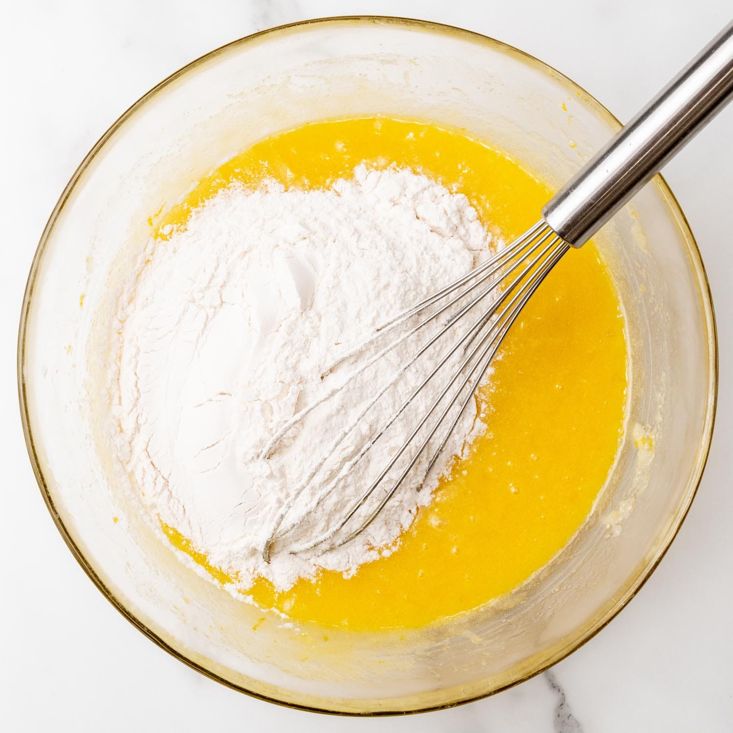 Flour added to a bowl with lemon brownie batter.