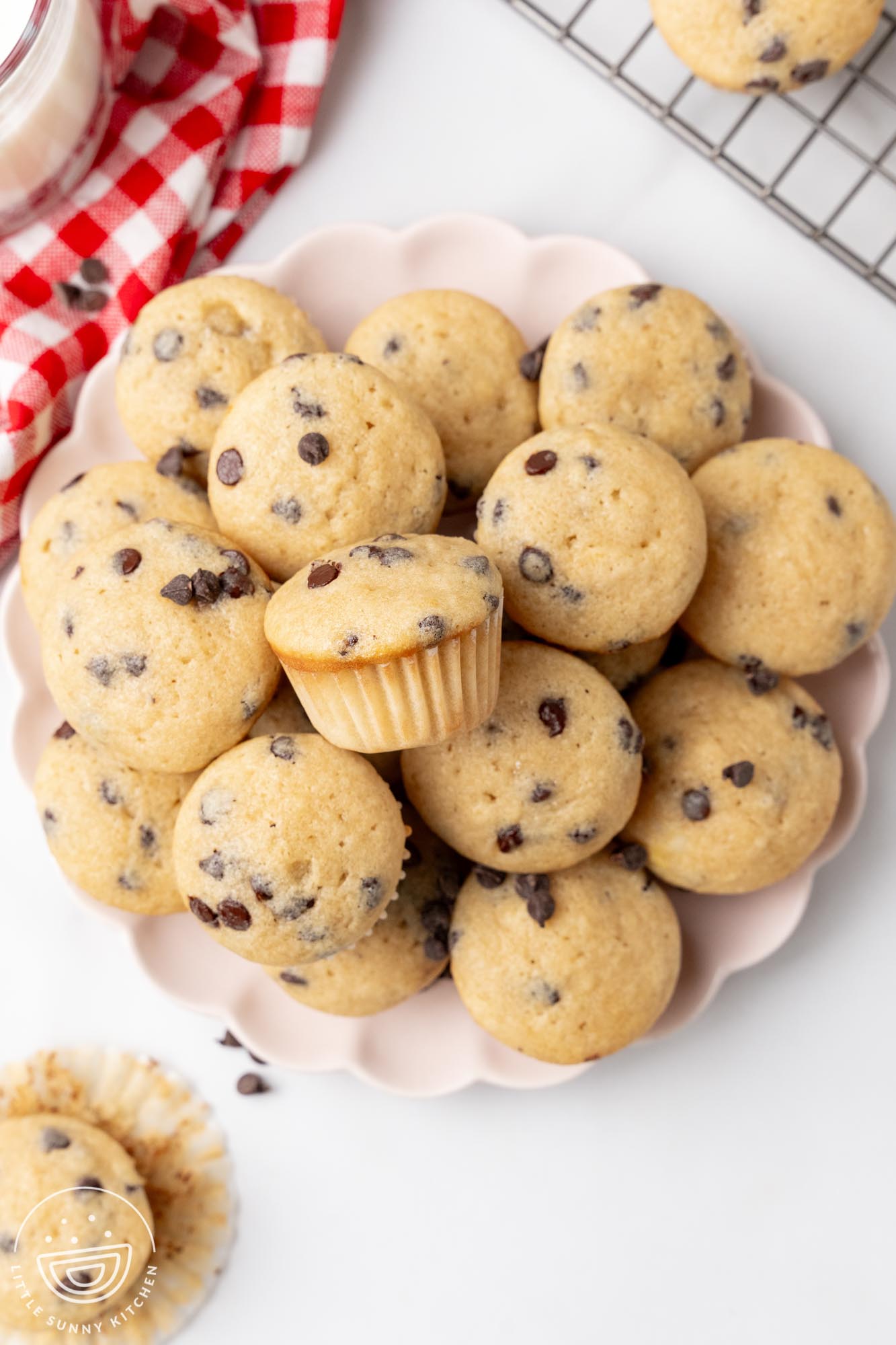 overhead view of a scalloped-edged plate holding chocolate chip mini muffins.