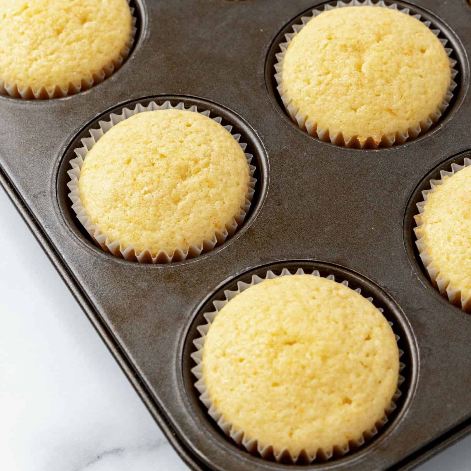 baked orange cupcakes, closeup to show the texture of the tops.