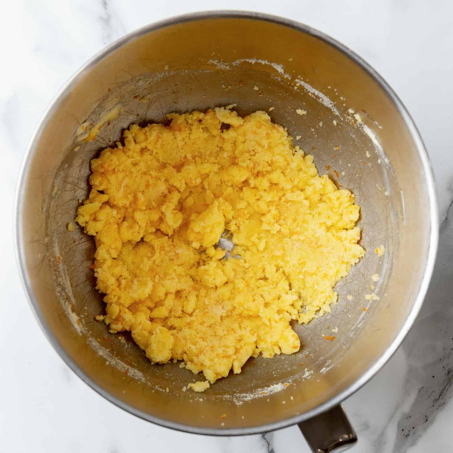 sugar, butter, and orange zest mixed in a metal mixing bowl.