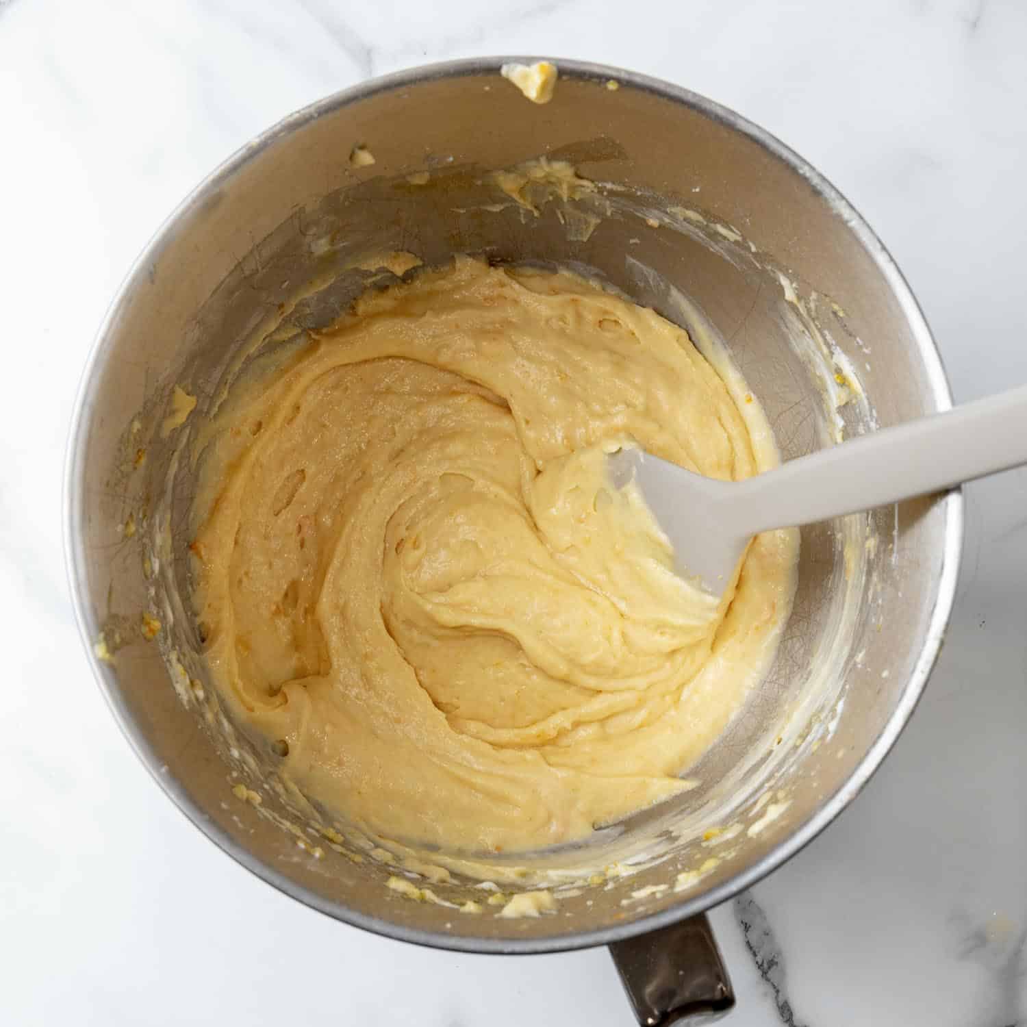 Orange cupcake batter in a mixing bowl.