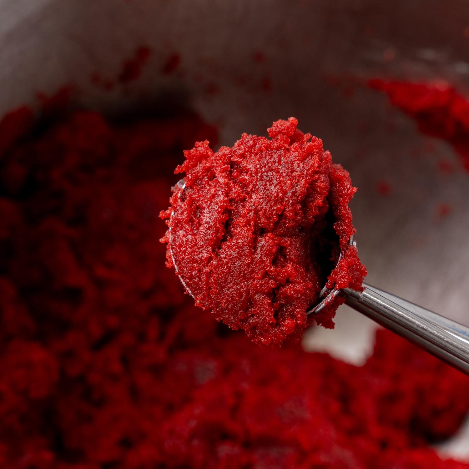 a cookie scoop portioning out red velvet cake pop dough.