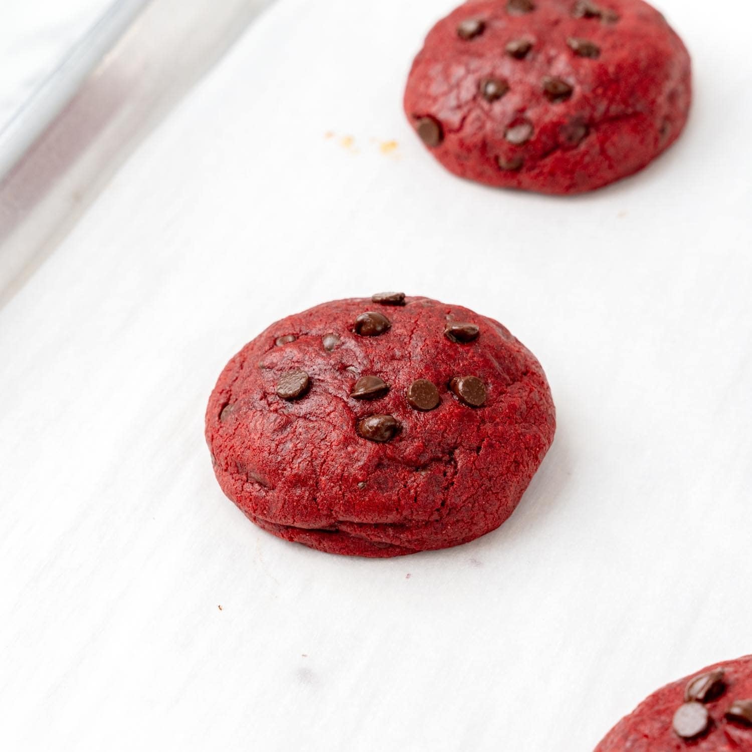 baked red velvet cream cheese cookies on parchment paper.