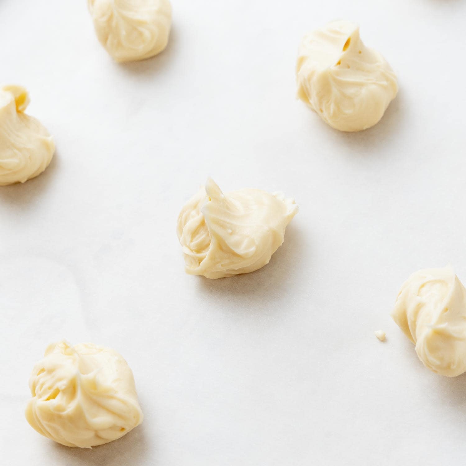 dollops of cream cheese filling on parchment paper.