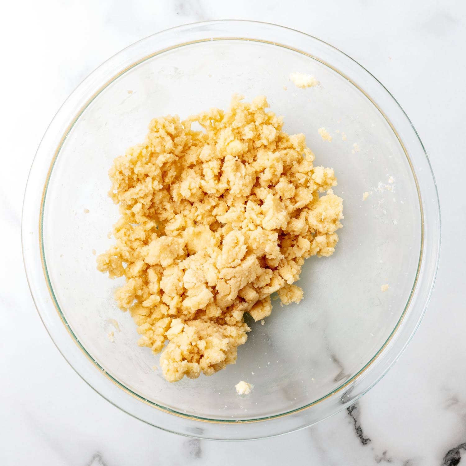 butter creamed with granulated and brown sugar in a glass mixing bowl.