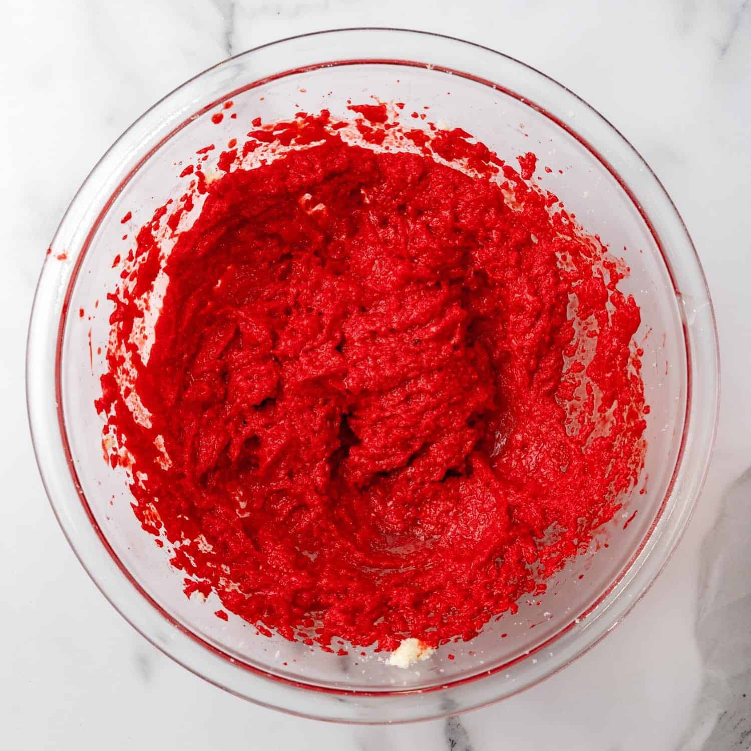 wet ingredients mixed for red velvet cookies, including red food coloring to create a deep color.