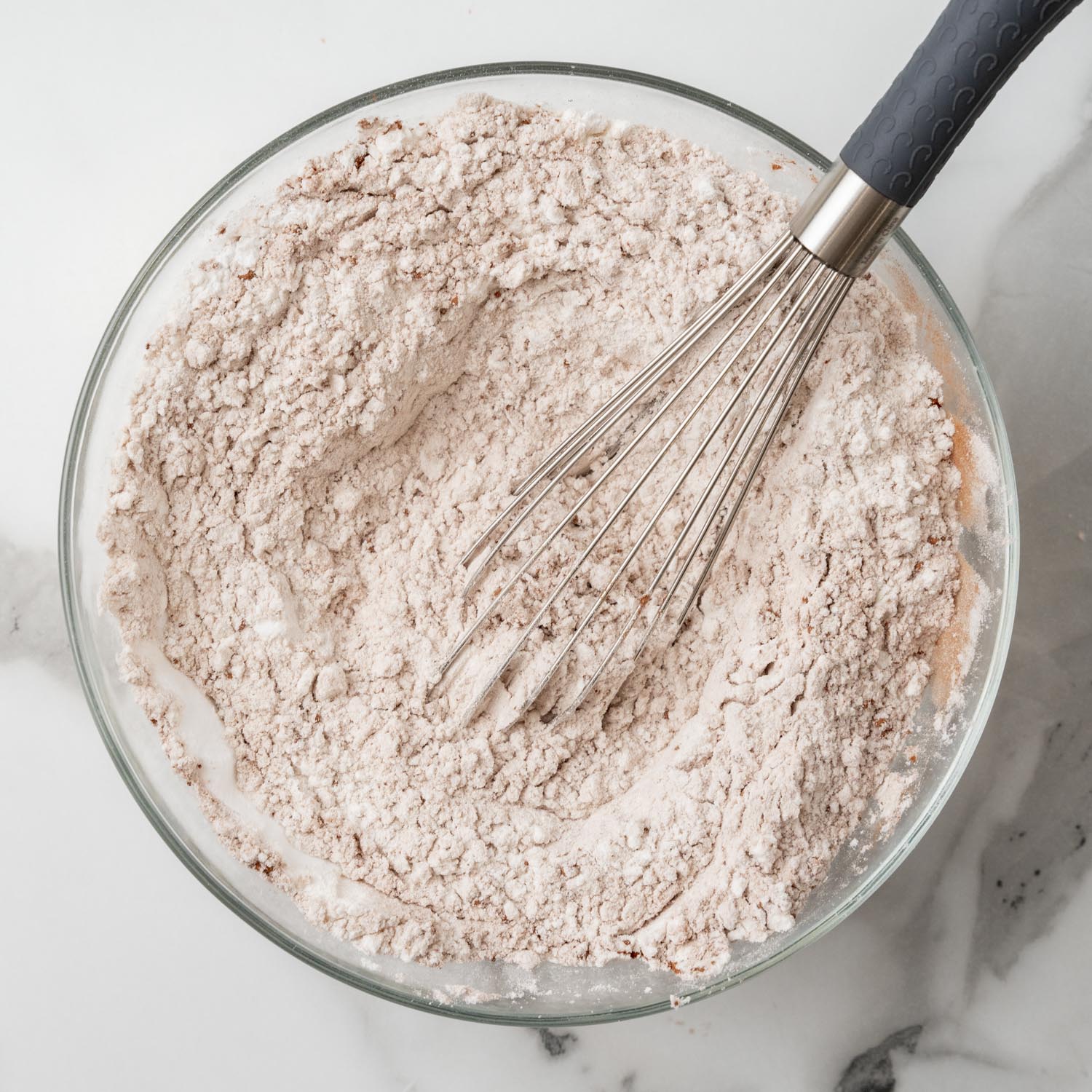 flour and cocoa powder whisked together in a glass bowl.