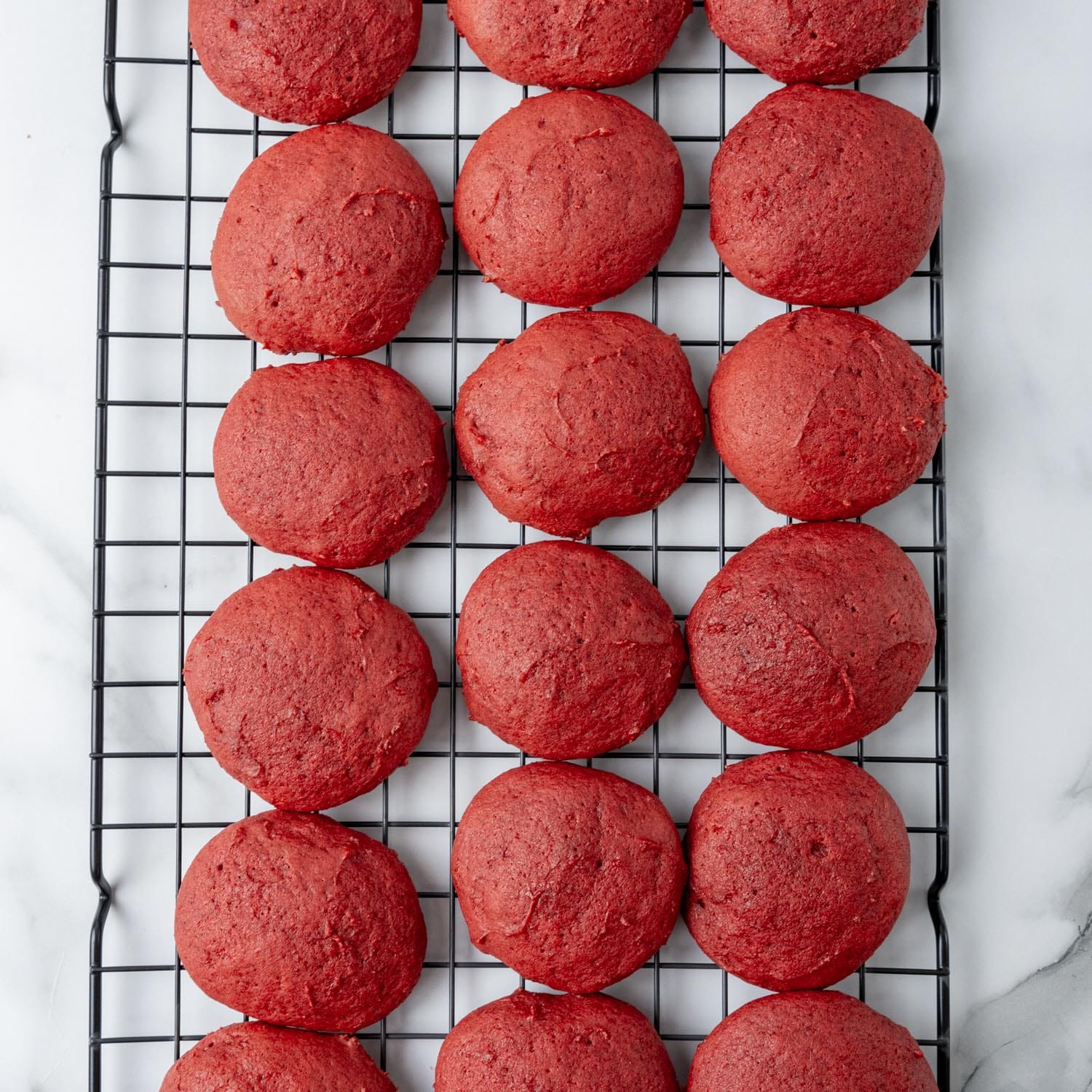 baked red velvet whoopie pie shells, colling on a wire rack.