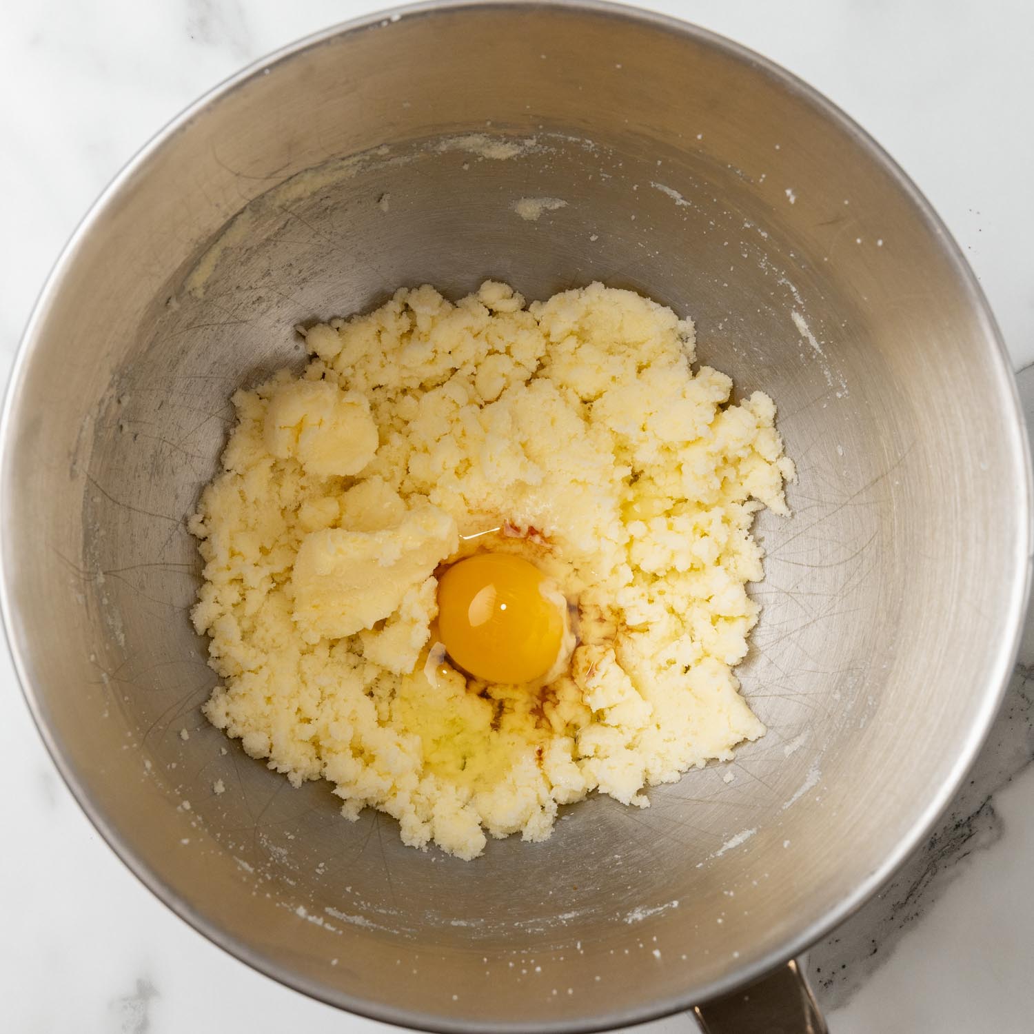 creamed butter and sugar in a mixing bowl with an egg added.