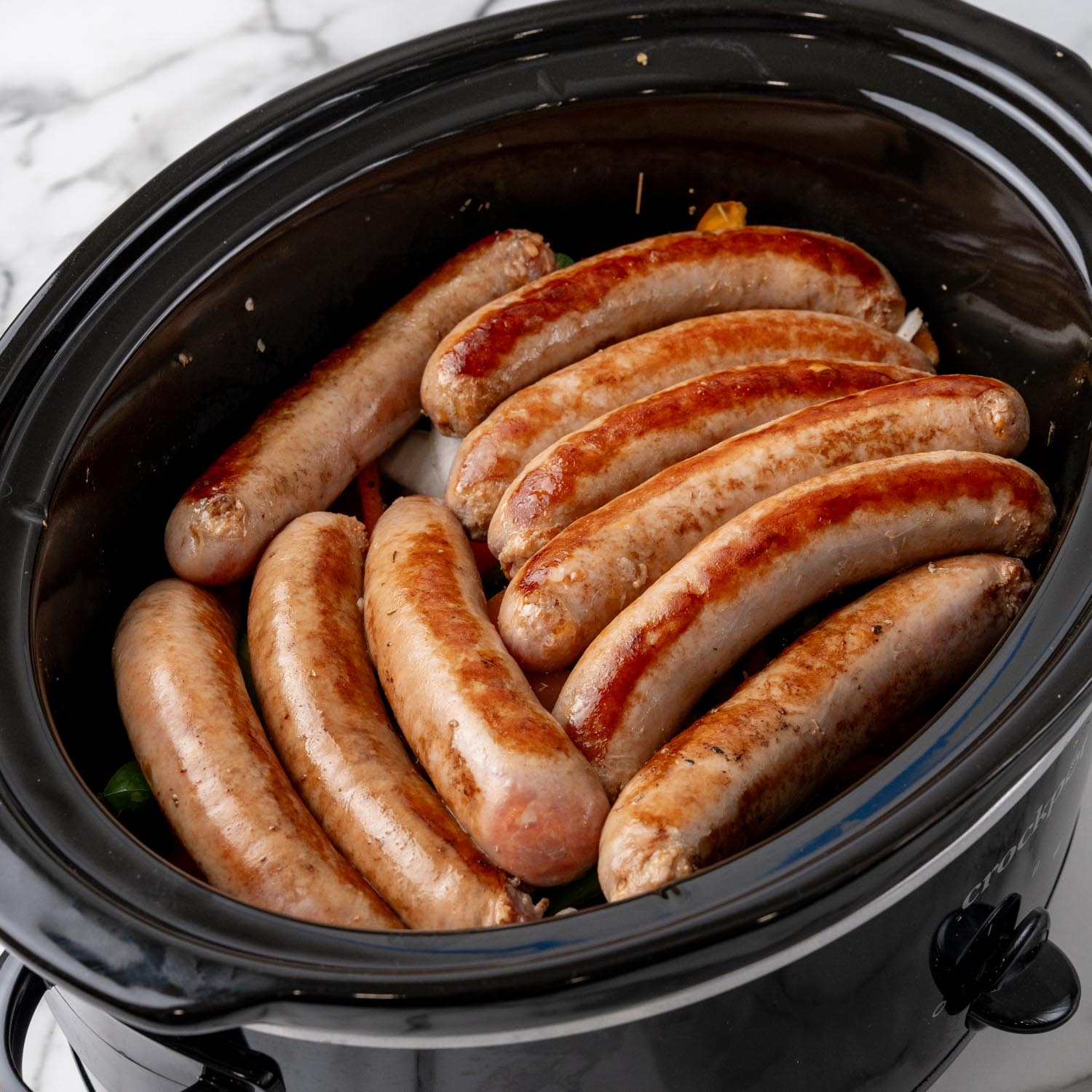 10 italian sausage links added to peppers and onions in a crock pot.