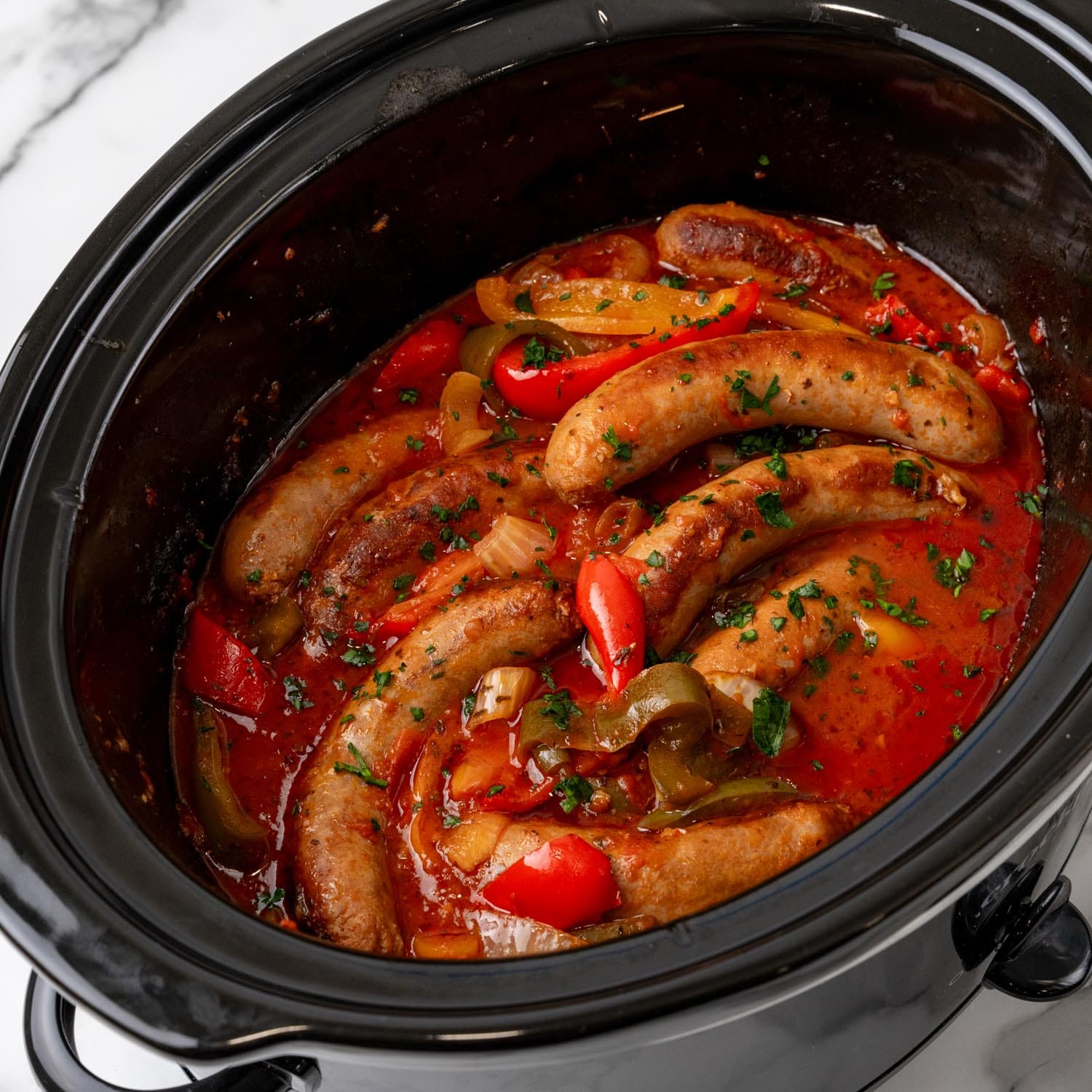 cooked sausage and peppers in marinara sauce in a crockpot.