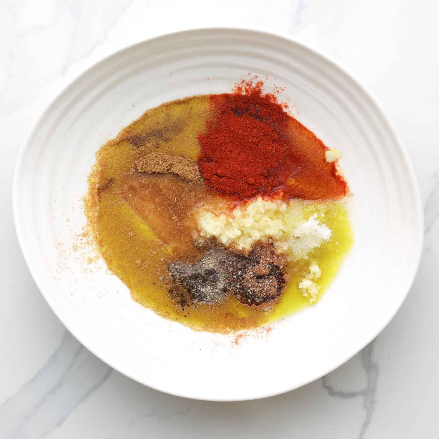 oil and seasonings for shawarma in an irregularly shaped ceramic bowl. 