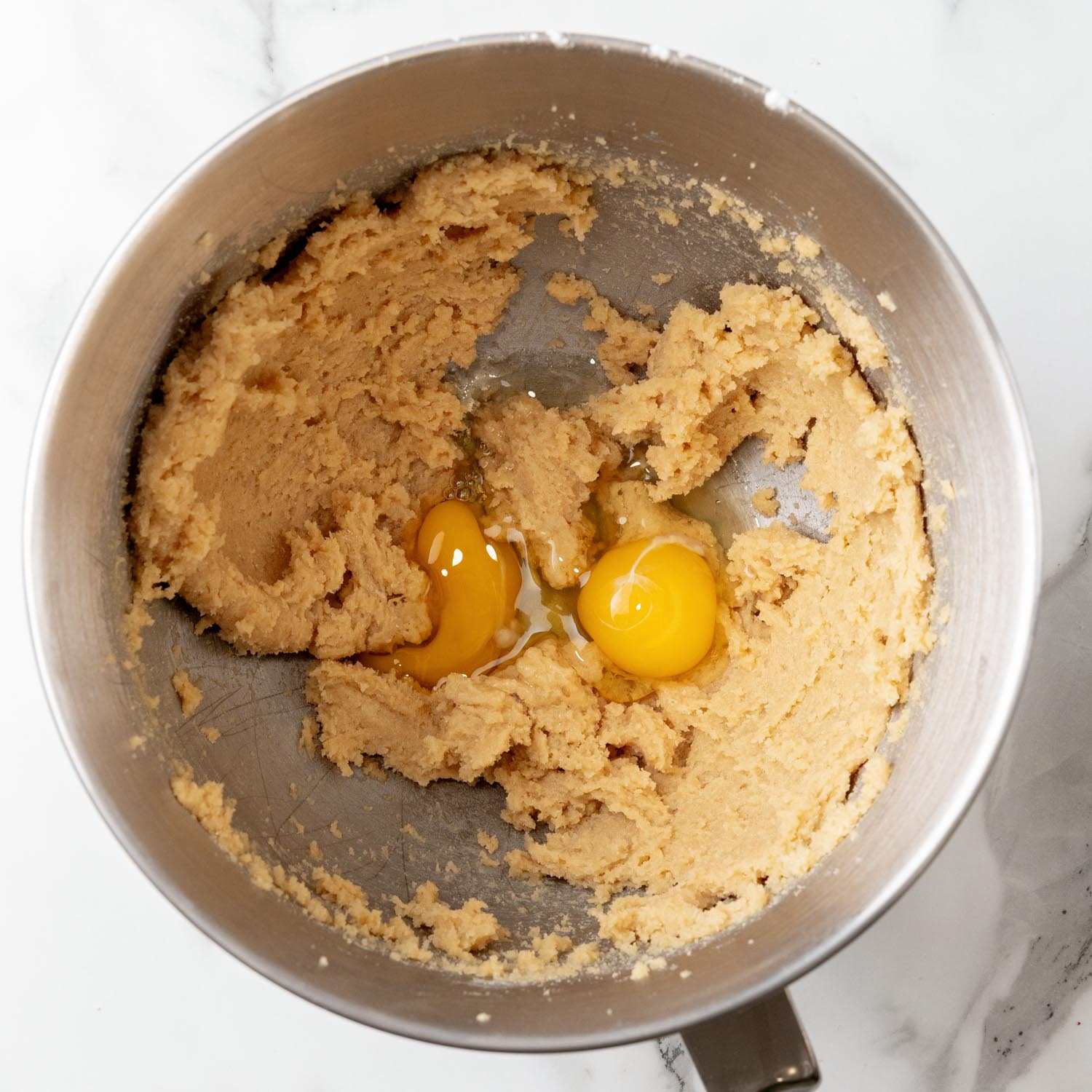 two eggs added to creamed butter and brown sugar in the bowl of a stand mixer.