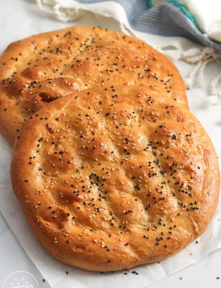 two loaves of pillowy ramazan pidesi topped with sesame seeds and nigella seeds