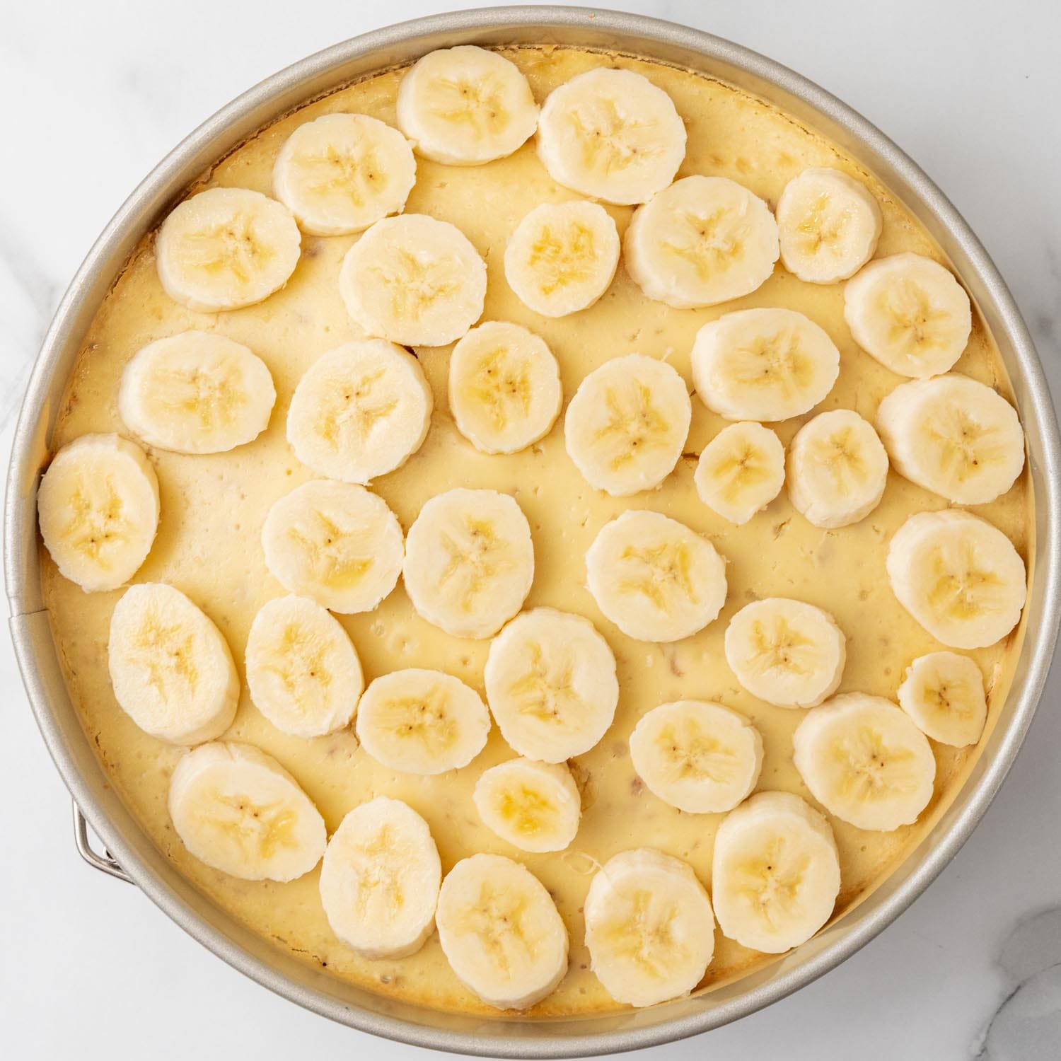 sliced bananas added to banana pudding cheesecake.