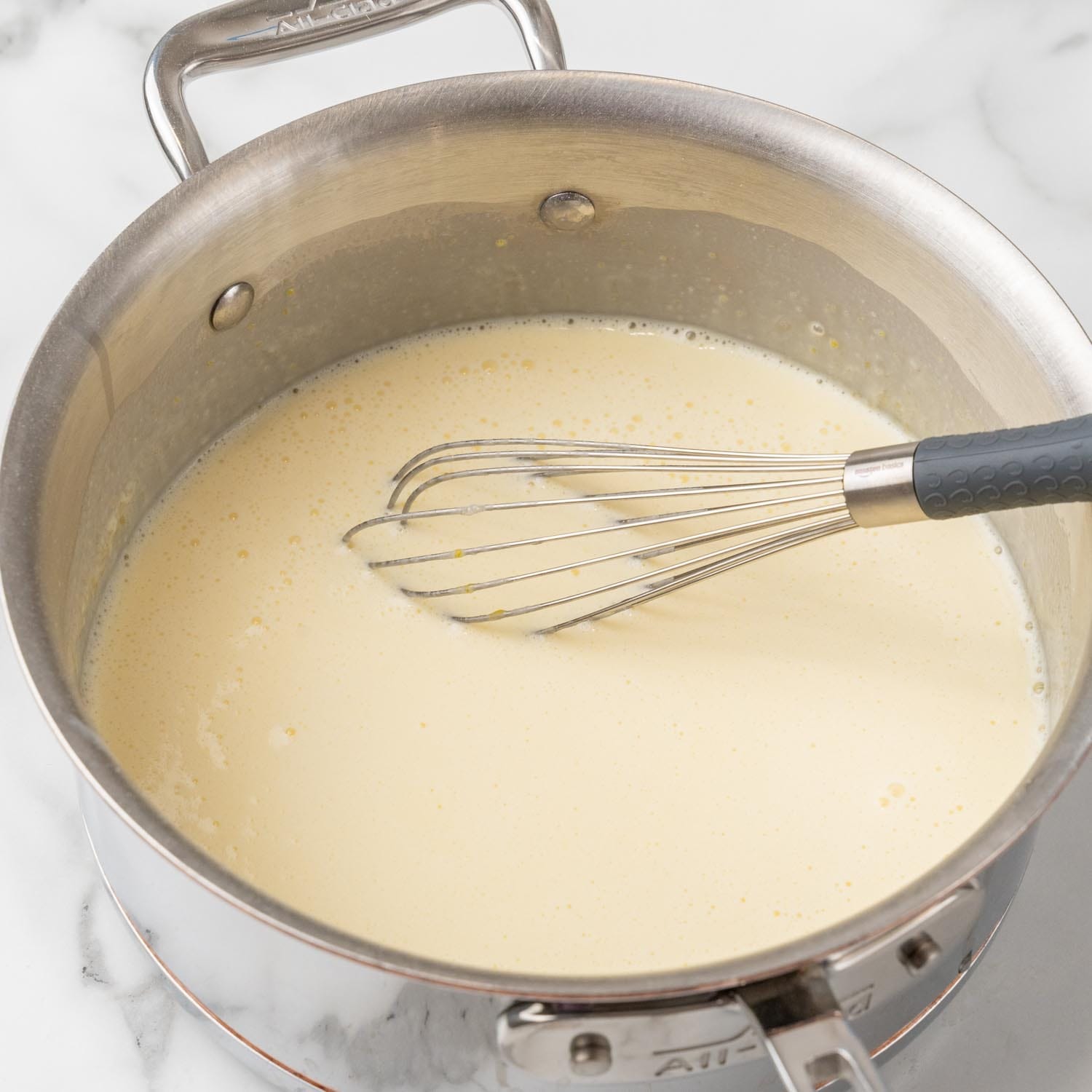 creamy topping for banana pudding cheesecake cooking in a saucepan.