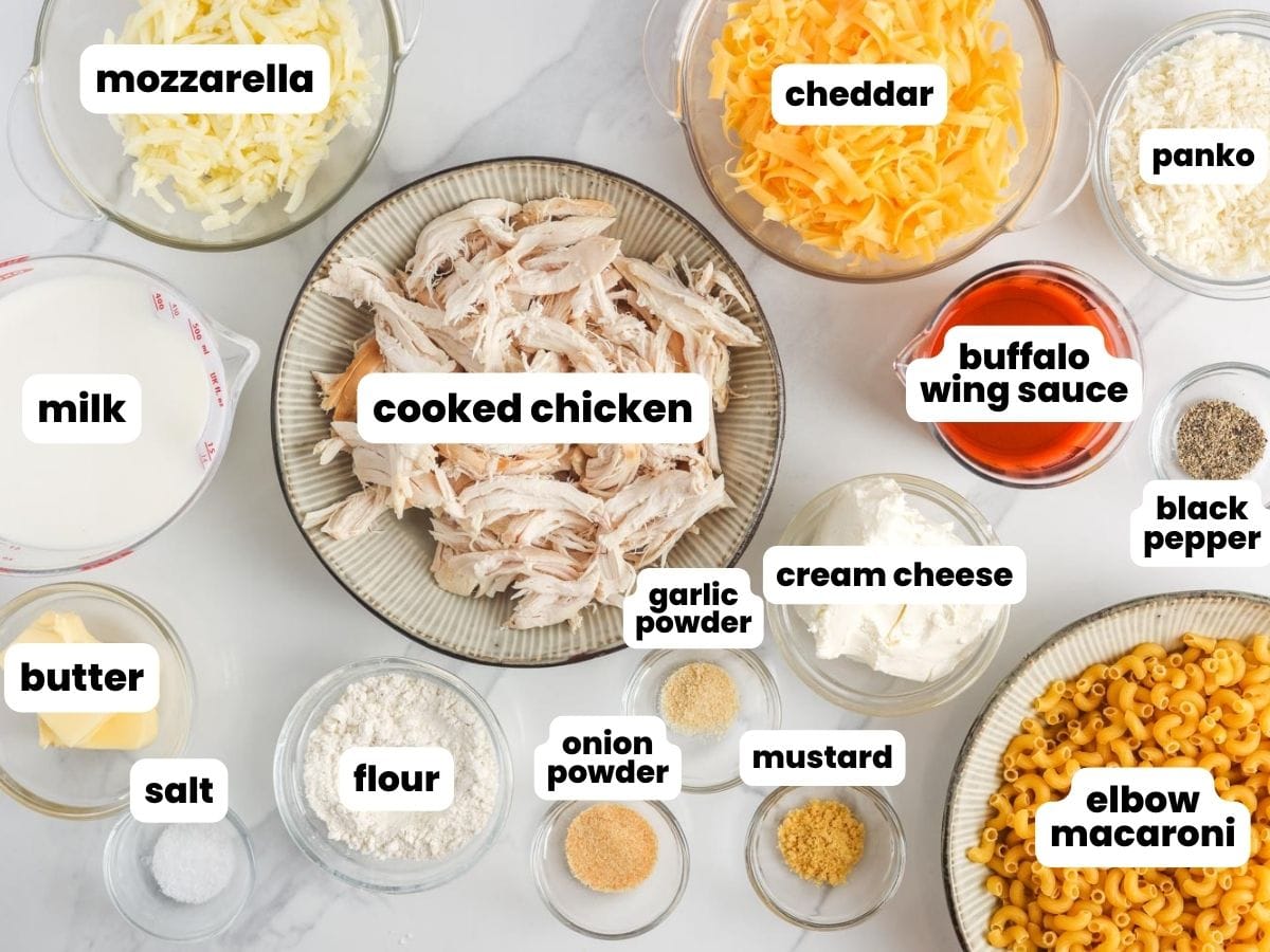 The ingredients for buffalo chicken mac and cheese including elbow macaroni, cheese, wing sauce, and shredded chicken.