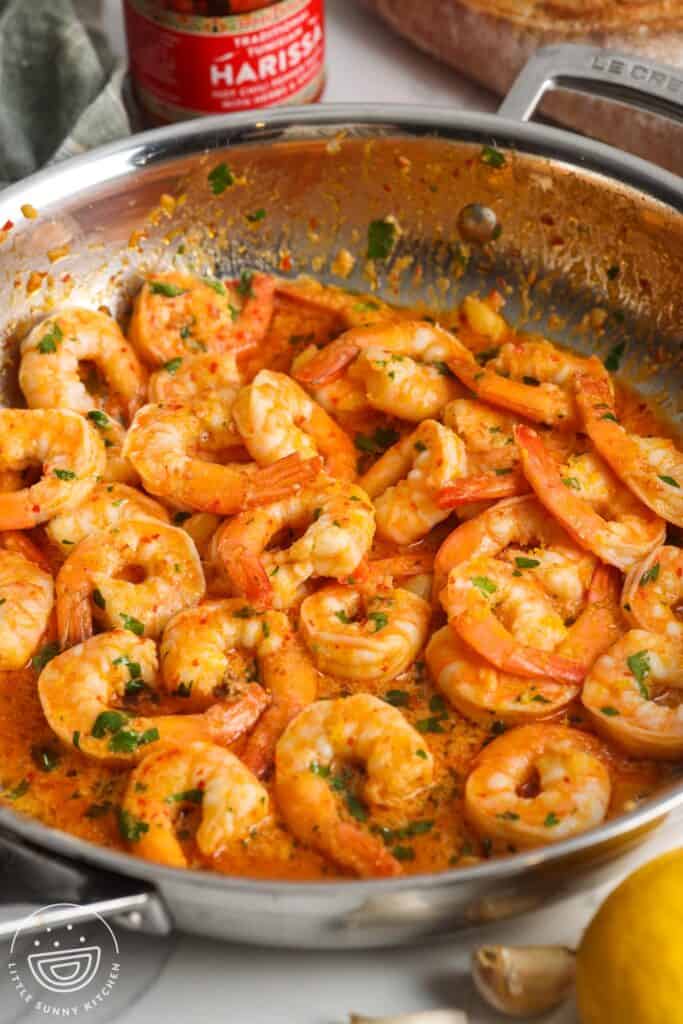 a skillet of cooked shrimp in harissa garlic sauce.