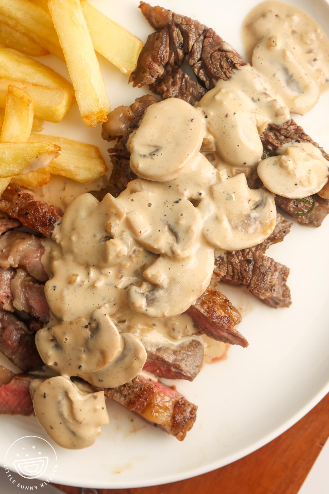 a plate of sliced steak with creamy mushroom sauce.