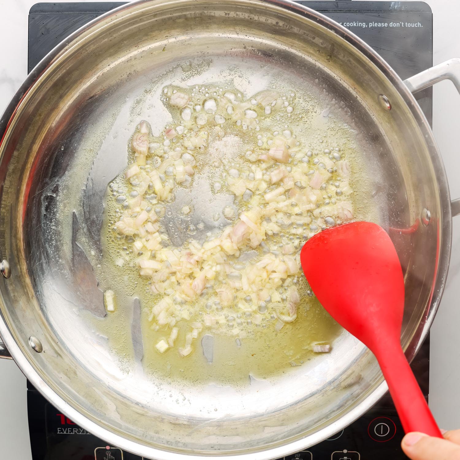 shallots sauteing in a pan with butter.