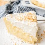 a generous slice of coconut cream pie on a white ceramic plate.
