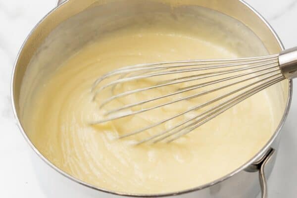 Filling for coconut cream pie whisked in a saucepan.