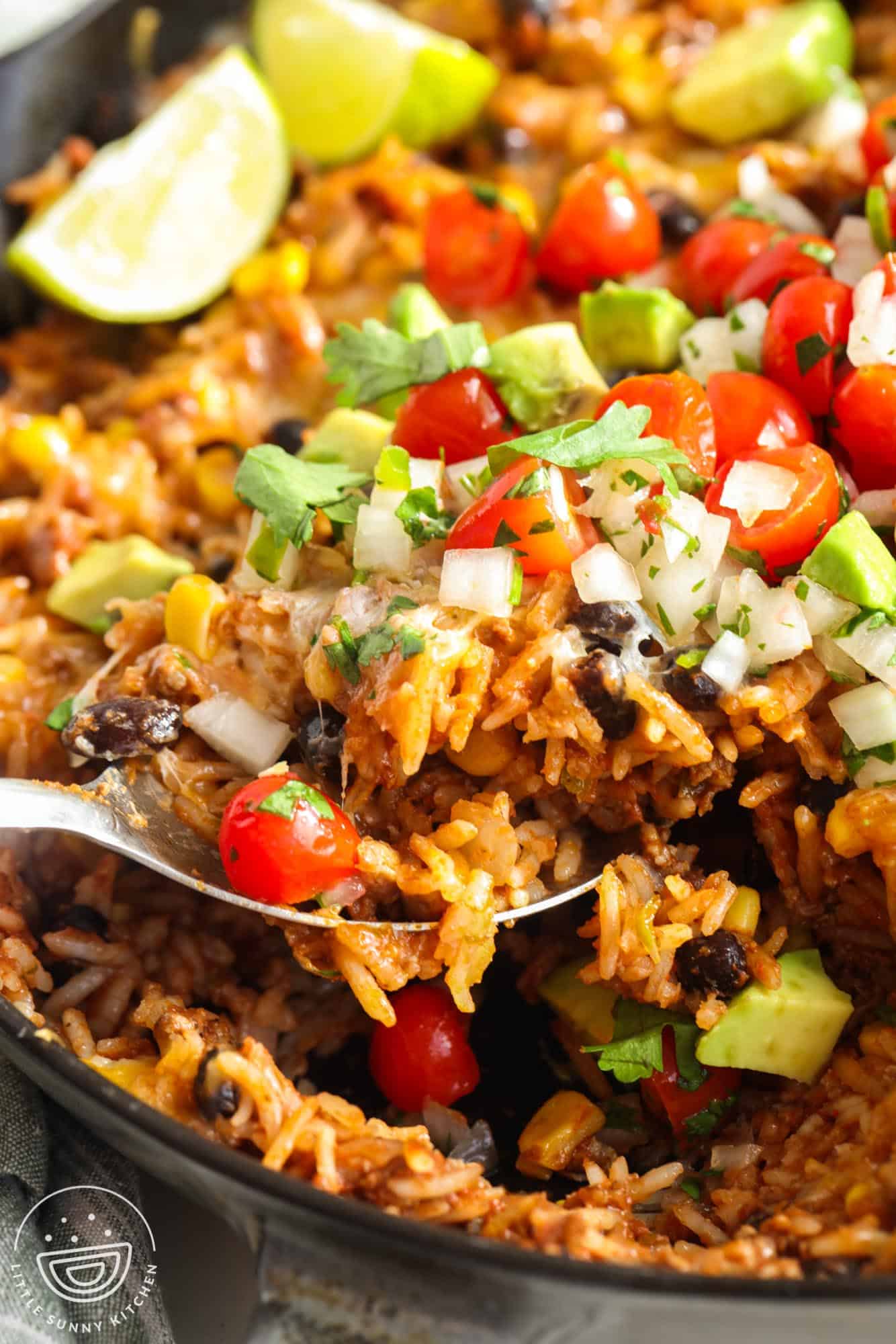 closeup of one pan Mexican beef and rice with fresh salsa topping.