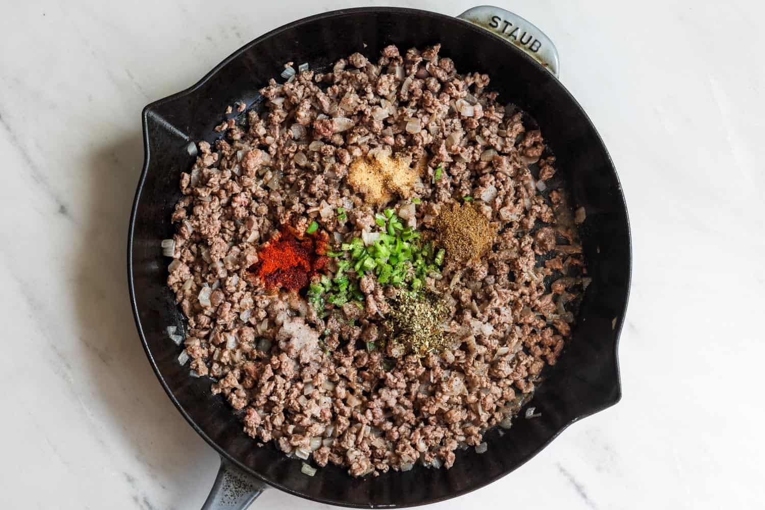 A skillet of cooked ground beef with mexican seasonings added.