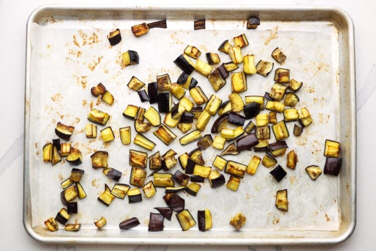 roasted diced eggplant pieces on a sheet pan.