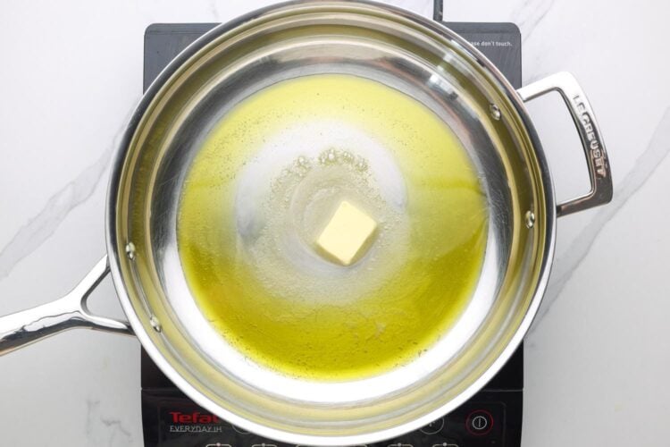 butter melting in a stainless steel skillet.