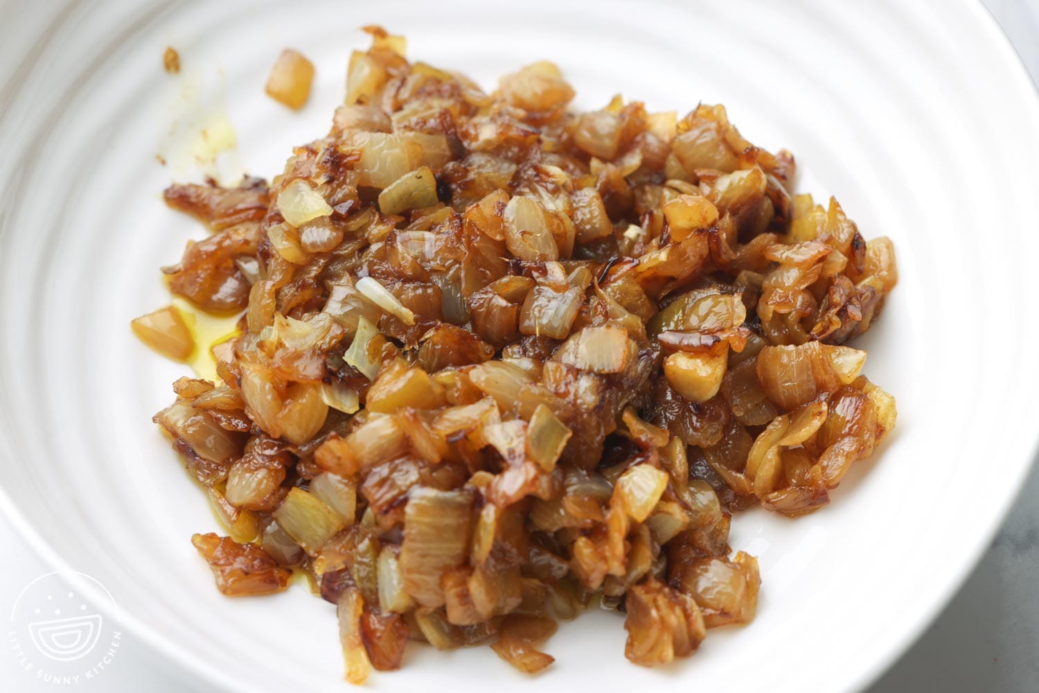 Caramelized diced onions in a white bowl