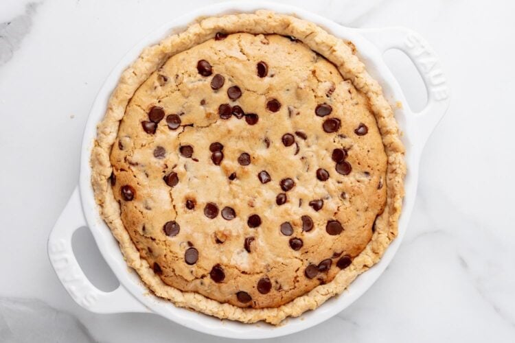 baked chocolate chip cookie pie viewed from overhead on a marble counter.